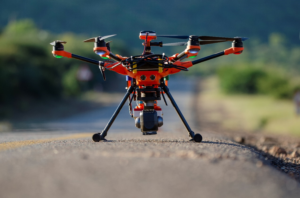 Multiparameter drone on the ground with a mounted camera and multi-spectral sensor, photographed from the front.