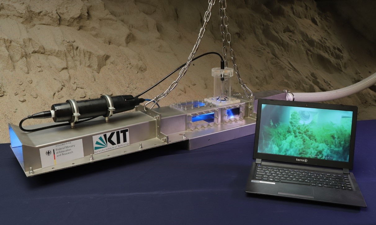 The photo shows the stainless steel underwater flow channel with plexiglass panels covering the measurement area. 