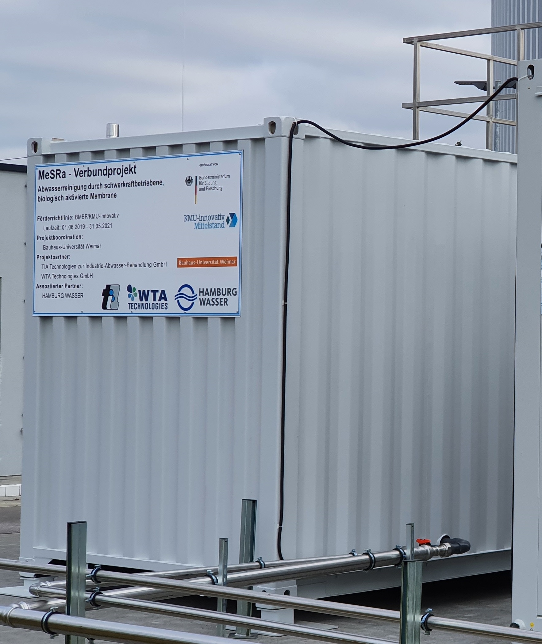 On this picture, two containers are depicted at an operation site. They are connected by pipes and set on adjustable foots.